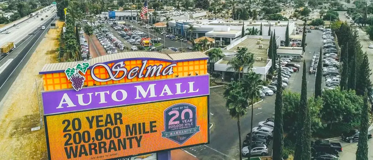 Aerial view of the Selma Auto Mall sign next to a highway, surrounded by car dealerships and parking lots.